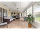 Spacious sunroom featuring neutral tile, ample seating, and large windows for natural light at 13715 Se 88Th Ct, Summerfield, FL 34491