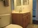 This bathroom includes a toilet, wooden vanity, and soft lighting at 14192 Sw 112Th Cir, Dunnellon, FL 34432