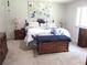 Spacious bedroom with plush carpeting, traditional furniture, and bright natural light from the window at 14192 Sw 112Th Cir, Dunnellon, FL 34432