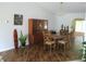 Dining area features wood floors, chandelier, a wood china cabinet, and large windows for natural light at 14192 Sw 112Th Cir, Dunnellon, FL 34432