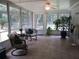 Bright Florida room with tile floors and wicker seating overlooking a backyard at 14192 Sw 112Th Cir, Dunnellon, FL 34432