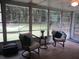 Enclosed Florida room with outdoor views, wicker seating, and tile floors at 14192 Sw 112Th Cir, Dunnellon, FL 34432