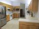 Spacious kitchen with stainless steel refrigerator, tile floors, and light wood cabinets at 14192 Sw 112Th Cir, Dunnellon, FL 34432