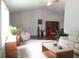 Bright living room featuring vaulted ceiling, ceiling fan, neutral decor, and a mix of wood and carpet floors at 14192 Sw 112Th Cir, Dunnellon, FL 34432