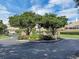 Community entrance with trees, flowers, and a decorative gate creating an inviting atmosphere at 145 Harbor Way, Auburndale, FL 33823