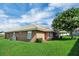 Exterior side view of the home showing well-maintained landscaping and a mature shade tree at 145 Harbor Way, Auburndale, FL 33823