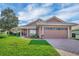 Charming single-story home with a well-manicured lawn and a two-car garage, set under a bright, partly cloudy sky at 145 Harbor Way, Auburndale, FL 33823