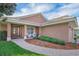 Home's front entrance with landscaped flower beds and a brick walkway with a pair of white chairs at 145 Harbor Way, Auburndale, FL 33823