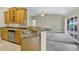 Open-concept kitchen boasts stainless steel appliances, wood cabinets, and a view of the living area at 145 Harbor Way, Auburndale, FL 33823
