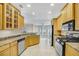 Bright kitchen showcases stainless steel appliances, wood cabinets, and overlooks an adjacent dining nook at 145 Harbor Way, Auburndale, FL 33823
