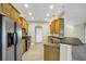 Well-lit kitchen featuring tile floors, stainless steel appliances, wood cabinets, and a breakfast bar at 145 Harbor Way, Auburndale, FL 33823