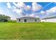 Large backyard featuring a grassy lawn, back patio, and beautiful blue skies, perfect for outdoor enjoyment and relaxation at 14863 Sw 60Th Ter, Ocala, FL 34473