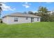 This single-story home offers a sliding glass door to the backyard along with a lush green lawn at 17277 Sw 44Th Cir, Ocala, FL 34473