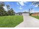 Beautiful single-story home with a large driveway, lush green lawn and mature trees at 17277 Sw 44Th Cir, Ocala, FL 34473