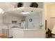 Bright kitchen with white cabinets, breakfast bar, white appliances and pass-through to living area at 17720 Se 115Th Ct, Summerfield, FL 34491