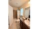 Comfortable bathroom featuring a vanity with granite countertops, a shower with curtain and a window at 186 Nw 44Th St, Ocala, FL 34475