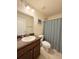 Well-lit bathroom featuring a vanity with a sink, a toilet, and a shower with a patterned curtain at 186 Nw 44Th St, Ocala, FL 34475