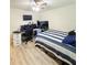 Bedroom with a striped bedspread and workspace featuring multiple monitors and a gaming chair at 186 Nw 44Th St, Ocala, FL 34475