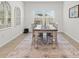 Elegant dining room featuring a wooden table, four chairs, stylish decor, and bright natural light at 19551 Sw 77Th Loop, Dunnellon, FL 34432