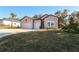 Charming home featuring a three-car garage, neutral siding, landscaped front yard and blue sky at 19551 Sw 77Th Loop, Dunnellon, FL 34432