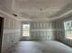 Spacious unfinished main bedroom with tray ceiling, smooth drywall, and natural light from two windows at 2 Pine Course Trl, Ocala, FL 34472