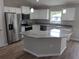 Modern kitchen featuring white cabinets, stainless steel appliances, gray countertops, and a center island at 23 Oak Pass Loop, Ocala, FL 34472