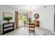 Bright dining area features a glass table, modern lighting, and a large window with backyard views at 2644 Sw 20 Cir, Ocala, FL 34471