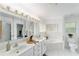 Bright bathroom with double sinks, marble countertops, and a large soaking tub with a glass block window at 2644 Sw 20 Cir, Ocala, FL 34471