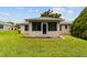 Rear exterior view of enclosed sunroom with access to the green backyard at 2644 Sw 20 Cir, Ocala, FL 34471