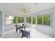 Bright sunroom with tile flooring, ceiling fan and large windows offering backyard views at 2644 Sw 20 Cir, Ocala, FL 34471