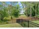 A fenced-in backyard featuring lush greenery and mature trees backing to a golf course at 32 Hickory Course Loop, Ocala, FL 34472