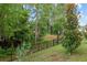 The fenced backyard features mature trees, green grass, and a well-maintained perimeter at 32 Hickory Course Loop, Ocala, FL 34472
