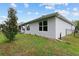 A well-kept backyard with mature trees, a covered patio, and a secure black fence on a sunny day at 32 Hickory Course Loop, Ocala, FL 34472