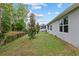 Wide view of the backyard with a secure fence, showcasing the ample space and mature landscaping on a sunny day at 32 Hickory Course Loop, Ocala, FL 34472