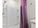 Bright bathroom featuring a tub-shower combo with a white surround and purple shower curtain at 32 Hickory Course Loop, Ocala, FL 34472