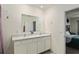 Bright bathroom featuring a double sink vanity with white cabinets and a large mirror at 32 Hickory Course Loop, Ocala, FL 34472