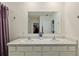 Bright bathroom featuring a double sink vanity with white cabinets and a large mirror at 32 Hickory Course Loop, Ocala, FL 34472