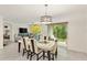 Dining room with a contemporary table setting, modern chandelier, and glass slider door to the outdoor patio at 32 Hickory Course Loop, Ocala, FL 34472