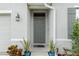 Inviting entryway featuring potted plants and a stylish light fixture at 32 Hickory Course Loop, Ocala, FL 34472