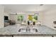 Kitchen island sink with stainless steel appliances, granite counters, and a view of the dining and living spaces at 32 Hickory Course Loop, Ocala, FL 34472