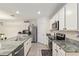 Bright kitchen featuring stainless steel appliances, granite countertops, and ample white cabinets and storage at 32 Hickory Course Loop, Ocala, FL 34472