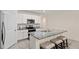 Modern kitchen featuring granite countertops, stainless appliances, an island with seating, and ample white cabinets at 32 Hickory Course Loop, Ocala, FL 34472