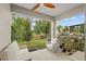 Covered outdoor patio with a ceiling fan, furniture and views of the backyard at 32 Hickory Course Loop, Ocala, FL 34472