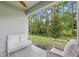 Covered outdoor patio features comfortable seating, a ceiling fan and views of the fenced yard at 32 Hickory Course Loop, Ocala, FL 34472