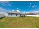Spacious backyard with a white fence, patio furniture under an umbrella, and green grass at 3418 Sw 155Th Pl, Ocala, FL 34473