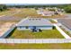 Aerial view of fenced backyard with green grass and patio setup with an umbrella and grill at 3418 Sw 155Th Pl, Ocala, FL 34473