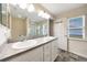 This bathroom has double sinks, gray tile floors, and a glass enclosed shower in the background at 3418 Sw 155Th Pl, Ocala, FL 34473