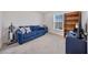 Comfortable bedroom featuring a blue sofa, window, and ample space for relaxation and rest at 3418 Sw 155Th Pl, Ocala, FL 34473