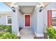 View of a charming home featuring a red front door with decorative columns and sidelight windows at 3418 Sw 155Th Pl, Ocala, FL 34473