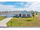 Charming single-story home with a well-manicured lawn, attached garage, and inviting red door at 3418 Sw 155Th Pl, Ocala, FL 34473